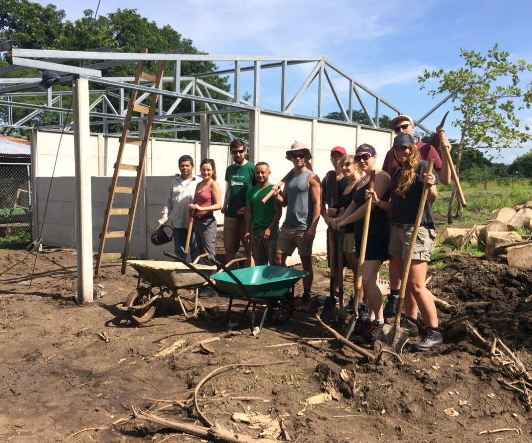 A group of corporate volunteers on a tailor-made trip take a break during building activities in Costa Rica. A corporate group on a bespoke volunteer trip at their building site in Costa Rica.